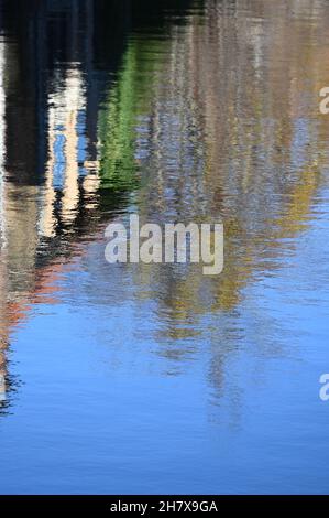 Ufer in herbstlichen Farben, die sich in einem Kanal in Brügge spiegeln Stockfoto