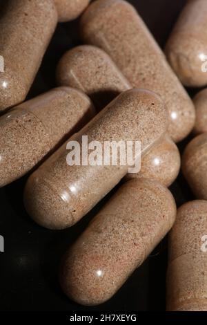 Transparente Kapseln gefüllt mit braunen Vitaminen Pulver Nahaufnahme Hintergrund hohe Qualität großen Druck Stockfoto