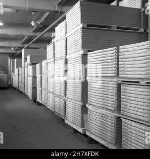 1950s, historisch, in einem Lagerhaus, auf Holzstützen, Stapeln von fertigen Papier, verpackt und beschriftet in der Papierfabrik von Brittains Limited, Cheddleton, England, Großbritannien. Das Papier wurde ursprünglich von Hand hergestellt, aber mit der Erfindung der Papiermaschine durch die Foudrinier-Brüder wurde die Industrie mechanisiert und die Briten wurden der Nachfolger der Brüder, die in Hanley eine Mühle betrieben. Thomas Brittain spielte eine wichtige Rolle in der Geschichte der Papierherstellung. Stockfoto