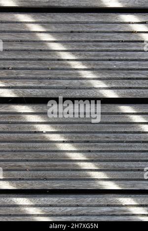 Sonnenstrahlen erzeugen ein Linienmuster auf dem Holzboden Stockfoto