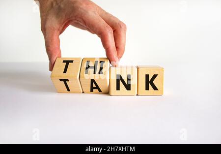 Symbol für Denkfabrik. Geschäftsmann dreht Holzwürfel und ändert das Wort „Tank“ in „denken“ oder umgekehrt. Schöner weißer Tisch, weißer Hintergrund, Kopie Stockfoto