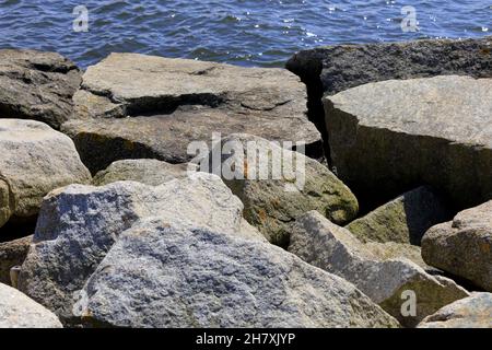 Steine schützen die Küste vor den zerstörerischen Auswirkungen großer Wellen bei stürmischem Wetter am Strand in Kolobrzeg, Polen Stockfoto