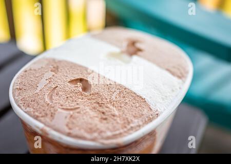 Nahaufnahme Makro von Behälter Karton Wanne von dunkler und Milch Schokolade Vanille neapolitanische Eis gefrorenen Dessert Gelato mit Textur der Milchprodukte gekauft Stockfoto