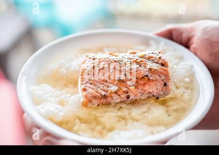 Gegrillter gekochter roter Sockeye-Lachs, Meeresfrüchte, Fischfilet, Nahaufnahme von weißer Reis-Ochazuke-japanischer Suppe in einer Schüssel mit Brühmakro Stockfoto