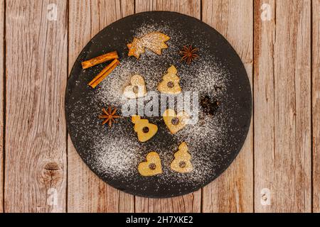 Leckere hausgemachte Kekse auf dunklen Teller.Weihnachts-Cookie-Muster.Winterferien Dessert Ornament Raum für Text.Weihnachten Gewürze.traditionelle Linzer Weihnachten Stockfoto