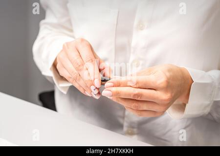 Professioneller Manikurist, der Werkzeuge für die Nagelpflege der Kunden vorbereitet Stockfoto