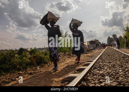 Während des internationalen Tages zur Beseitigung der Gewalt gegen Frauen in den Slums von Kibera werden Frauen gesehen, die entlang der Eisenbahnlinie mit ihren Einkaufstaschen auf dem Kopf gehen. Die meisten Frauen verstecken sich in Stille und Schmerz hinter den Türen, um nicht bemerkt zu werden, und kämpfen und fürchten, ihr Zuhause zu verlieren, ohne dass sich jemand oder nichts zuwenden kann. Wie heute die internationale 16-Tage-Kampagne in 30 Jahren markiert, ist es auch einer der besonderen Tage für die meisten Frauen, die körperlich, psychisch und sexuell verletzt wurden, gehört zu werden, während wir helfen, Gewalt gegen Frauen zu beseitigen. (Foto von Donwilson O Stockfoto