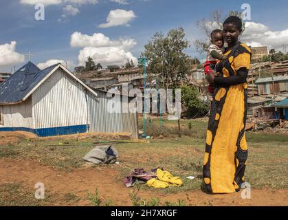 Nairobi, Kenia. 25th. November 2021. Eine Frau, die mit ihrem Sohn auf der Straße posiert, Während des internationalen Tages zur Beseitigung der Gewalt gegen Frauen in den Slums von Kibera verstecken sich die meisten Frauen vor den Türen in Stille und Schmerz, um nicht bemerkt zu werden, und kämpfen und fürchten, ihre Häuser zu verlieren, an die sich niemand oder nichts wenden kann. Wie heute die internationale 16-Tage-Kampagne in 30 Jahren markiert, ist es auch einer der besonderen Tage für die meisten Frauen, die körperlich, psychisch und sexuell verletzt wurden, gehört zu werden, während wir helfen, Gewalt gegen Frauen zu beseitigen. Quelle: SOPA Images Limited/Alamy Live N Stockfoto