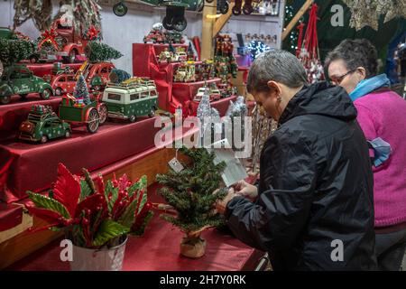 Barcelona, Spanien. 25th. November 2021. Weihnachtsverkäufern werden dabei gesehen, wie sie ihre Stücke in ihrem Hüttengeschäft platzieren.Barcelona bereitet die Fira de Santa Llúcia vor, einen traditionellen Weihnachtsmarkt im Freien vor der Kathedrale von Barcelona, da der obligatorische Covid 19-Pass in der Halle in Kraft tritt. (Foto von Paco Freire/SOPA Images/Sipa USA) Quelle: SIPA USA/Alamy Live News Stockfoto