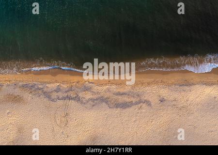 Luftaufnahme von oben auf den wunderschönen weißen Sandstrand, der von klarem türkisfarbenem Meerwasser durchflutet ist. Stockfoto