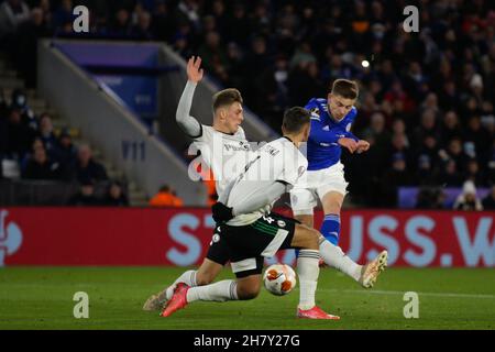 Leicester, Großbritannien. 25th. November 2021. Harvey Barnes (7), Mittelfeldspieler von Leicester City, versucht am 25. November 2021 im King Power Stadium, Leicester, England, einen Torschuss an Mateusz Holownia, Verteidiger von Legia Warsaw (3) und Mateusz Wieteska (4), Verteidiger von Legia Warsaw, während des UEFA Europa League Gruppenbühnentauches zwischen Leicester City und Legia Warsaw. Foto von Jurek Biegus. Nur zur redaktionellen Verwendung, Lizenz für kommerzielle Nutzung erforderlich. Keine Verwendung bei Wetten, Spielen oder Veröffentlichungen einzelner Clubs/Vereine/Spieler. Kredit: UK Sports Pics Ltd/Alamy Live Nachrichten Stockfoto