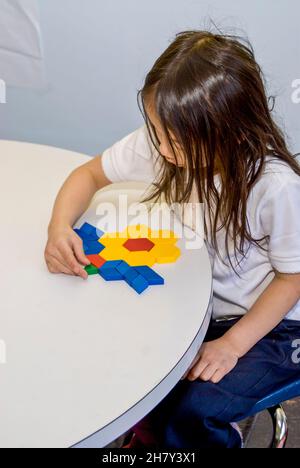 St. Paul, Minnesota. Charterschule für die Hmong. Hmong-Kindergarten-Student baut eine Blume mit Musterblöcken. Stockfoto