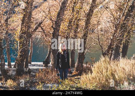 Weibliche Reisende erkunden Bergsee gegen Bäume im Herbst Stockfoto