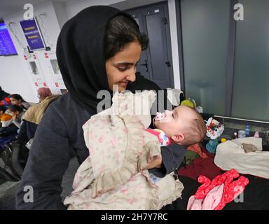 Minsk, Weißrussland. 25th. November 2021. Gestrandete irakische Migranten warten auf die Rückkehr in den Irak am internationalen Flughafen von Minsk in Minsk, Weißrussland, 25. November 2021. Das irakische Außenministerium sagte am Donnerstag, dass es 617 Migranten, die in Belarus gestrandet sind, evakuiert habe, von denen die meisten Frauen, Kinder und ältere Menschen sind. Tausende von Migranten haben sich auf der weißrussischen Seite der Grenze zu Polen versammelt, um nach Polen und dann nach Deutschland einzureisen, um in europäischen Ländern Asyl zu beantragen. Quelle: Henadz Zhinkov/Xinhua/Alamy Live News Stockfoto