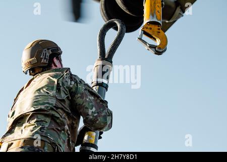 Ein Flieger der 820th Base Defence Group, 93d Air Ground Operations Wing, hakt ein hochmobiles Mehrzweck-Fahrzeug mit Rollen auf einen Marine Corps CH-53 „Super Hengst“-Hubschrauber auf der Moody Air Force Base, Georgia, am 17. November 2021. Der 93d Air Ground Operations Wing, das Marine Heavy Helicopter Squadron 366 und das Army National Guard Warrior Training Center führten ein Schlingentraining durch, um eine effiziente Luftaufnahme und -Lieferung zu üben. (USA Luftwaffe Foto von 1st LT. Katie Tamesis) Stockfoto