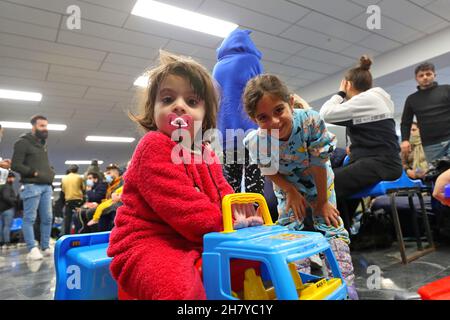 Minsk, Weißrussland. 25th. November 2021. Gestrandete irakische Migranten warten auf die Rückkehr in den Irak am internationalen Flughafen von Minsk in Minsk, Weißrussland, 25. November 2021. Das irakische Außenministerium sagte am Donnerstag, dass es 617 Migranten, die in Belarus gestrandet sind, evakuiert habe, von denen die meisten Frauen, Kinder und ältere Menschen sind. Tausende von Migranten haben sich auf der weißrussischen Seite der Grenze zu Polen versammelt, um nach Polen und dann nach Deutschland einzureisen, um in europäischen Ländern Asyl zu beantragen. Quelle: Henadz Zhinkov/Xinhua/Alamy Live News Stockfoto