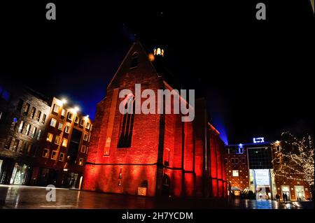 Nijmegen, Niederlande. 25th. November 2021. Die Marienburg-Kapelle sticht unter den umliegenden Gebäuden hervor, da sie mit orangefarbenen Lichtern beleuchtet wurde. Die Kampagne Orange the World, eine weltweite Kampagne zur Beendigung der Gewalt gegen Frauen, hat heute begonnen. Gebäude in den Niederlanden wurden mit orangefarbenen Lichtern beleuchtet. Orange ist die designierte Farbe, die die UN-Generalsekretärin bis 2030 zur Kampagne „Unite“ (Unite-Kampagne) zur Beendigung von Gewalt gegen Frauen führt. Kredit: SOPA Images Limited/Alamy Live Nachrichten Stockfoto