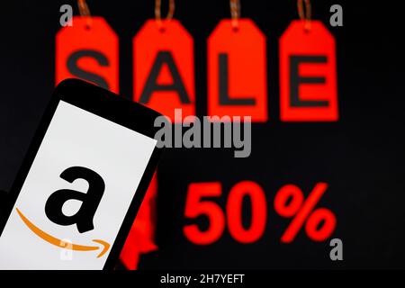 Polen. 24th. November 2021. In dieser Abbildung wird ein Amazon-Logo auf einem Smartphone mit einem 50 %-Angebot im Hintergrund angezeigt. Kredit: SOPA Images Limited/Alamy Live Nachrichten Stockfoto