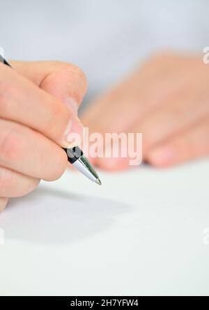 Die Hand des Geschäftsmanns hält weißes Papier und einen Stift mit Kopierplatz Stockfoto