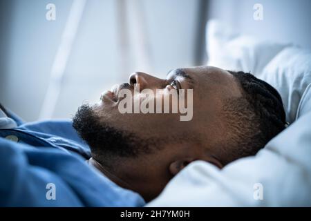 Junger Mann, Der An Schlaflosigkeit Leidet Und In Seinem Bett Liegt Stockfoto