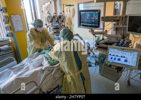 22. November 2021, Sachsen-Anhalt, Halle (Saale): Intensivkrankenschwestern betreuen einen schwer erkrankten Patienten mit Covid-19 auf dem Corona ITS im Universitätsklinikum Halle/Saale. Das Krankenhaus ist ein Zentrum für die Behandlung von Covid-19-Patienten in der Region. Foto: Hendrik Schmidt/dpa-Zentralbild/dpa Stockfoto