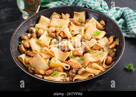 Pasta Calamarata mit Hühnerfleisch, Pilzen und Sojasauce. Italienische Küche. Stockfoto