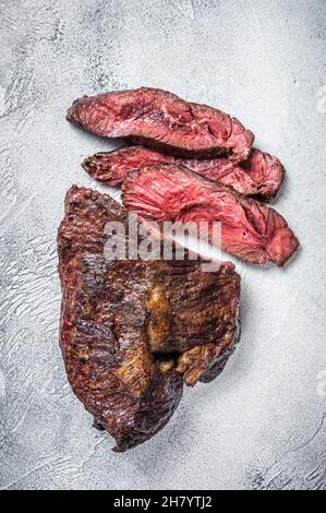 Gebratener Aufhänger oder Onglet-Rindersteak in Scheiben auf einem Tisch. Weißer Hintergrund. Draufsicht Stockfoto