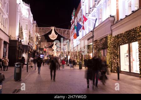 Dublin, Irland - 24. November 2021: Die Käufer gehen unter den kürzlich beleuchteten Weihnachtslichtern auf der Henry Street, der Einkaufsstraße auf der Stockfoto