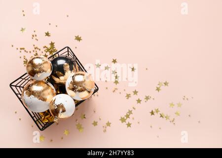 Weihnachtliche weiße und schwarze Kugeln verziert Gold Potal auf rosa Hintergrund. Weihnachtskarte mit Kopierplatz. Moderner Luxus-Metallic-Stil. Stockfoto