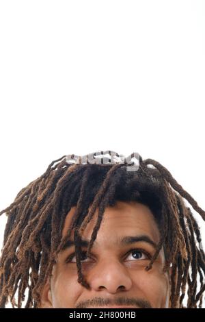 Nahaufnahme eines Mannes mit Dreadlocks, der vor einem weißen Hintergrund aufschaut. Stockfoto