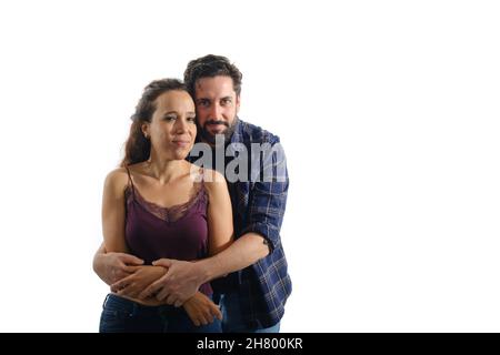 Schönes und glückliches Paar, das sich umarmt, während es über einem isolierten Hintergrund steht. Stockfoto