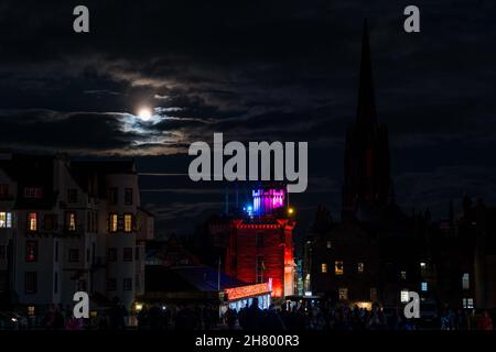 Ein Vollmond hinter Wolken bei Nacht von der Royal Mile aus gesehen mit Camera Obscura und beleuchteten Weihnachtslichtern, Edinburgh, Schottland, Großbritannien Stockfoto