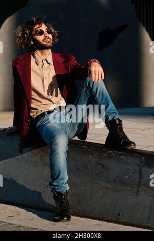 Der junge Mann entspannte sich, während er draußen saß. Stockfoto