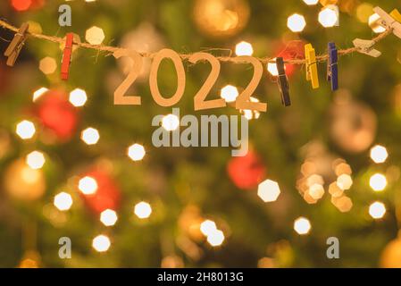 2022 Frohes neues Jahr. Weihnachtskonzept und Hintergrund mit Kiefernästen, Lichtern und Bällen. Stockfoto