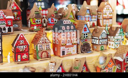 Alte Häuser stehen auf einem Regal. Mittelalterliche europäische bunte Häuser aus Keramik. Souvenirs auf dem Weihnachtsmarkt. Altstadtspielzeug. Stockfoto