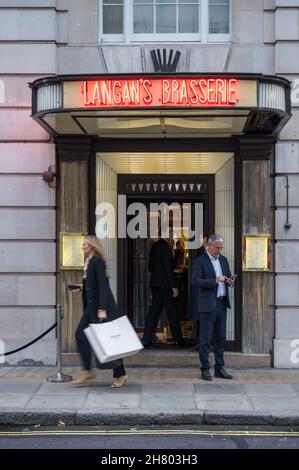 Menschen am Haupteingang von Langan's Brasserie. Stratton Street, Mayfair, London, England, Großbritannien Stockfoto