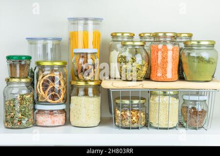 Vielfalt an vegetarischen Produkten und Pasta in Gläsern für die Lagerung auf weißem Holztisch. Gesundes veganes Kochen, viele Zutaten, Zero Waste Konzept. Stockfoto