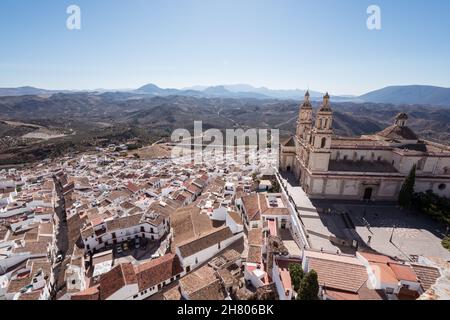 Drohnenansicht der alten Stadt mit Gebäuden in der Nähe des historischen Olvera Schlosses mit Türmen in Ronda in der Nähe von grasbewachsenen Hügeln Stockfoto