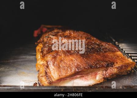 Köstliche gegrillte Schweinefleischrippen mit Kruste auf Metallgestell in modernen Grill-Maschine mit Racks in Licht Café platziert Stockfoto