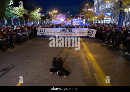 Madrid, Spanien. 25th. November 2021. Während einer Demonstration zum Internationalen Tag zur Beseitigung der Gewalt gegen Frauen liegt eine Frau auf Flor, gebunden an Kochtöpfe. Quelle: Marcos del Mazo/Alamy Live News Stockfoto