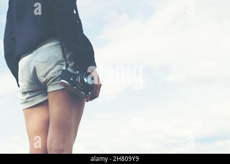 Schöne Frauen Fotografie stehend Hand retro Kamera in den Park. Stockfoto