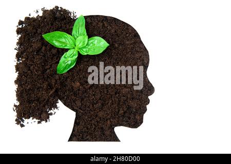 Frauenkopfprofil aus Erde mit einer Babypflanze, die auf Weiß isoliert ist. Frauen in der Landwirtschaft. Stockfoto