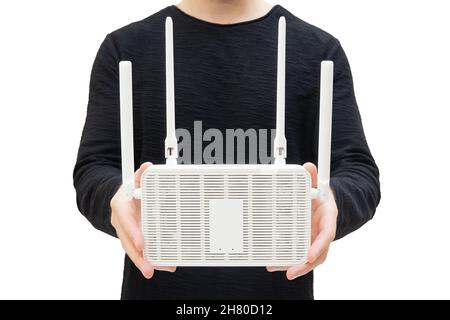 Mann in einem schwarzen Langarm, der einen modernen Dualband wi-Fi 6 Router in den Händen hält. Stockfoto