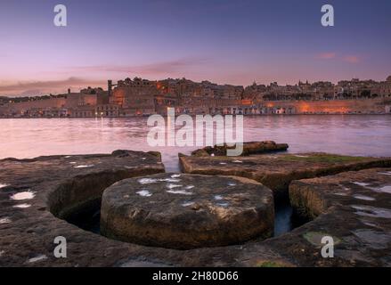 Valletta in der Abenddämmerung, über das Wasser gesehen. Stockfoto