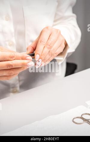 Professioneller Manikurist, der Werkzeuge für die Nagelpflege der Kunden vorbereitet Stockfoto