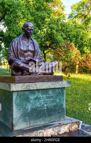 Statue von Mahatma Gandhi beim Lesen eines Buches im Ariana Park, Genf, Schweiz Stockfoto