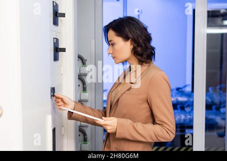 Seitenansicht des Technikers mit digitaler Tablet-Bedienzentrale im Rechenzentrum Stockfoto