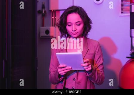 Junge Frau, die im Rechenzentrum ein digitales Tablet nutzt Stockfoto