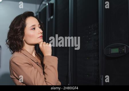 Eine durchdachte Frau, die sich den Server ansieht, während sie im Rechenzentrum arbeitet Stockfoto