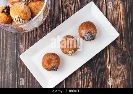 Bombolon oder Bomboloni ist ein italienisches gefülltes Donut- und Snackfutter. Deutsche Krapfen - Krapfen oder berliner - gefüllt mit Marmelade und Schokolade Stockfoto